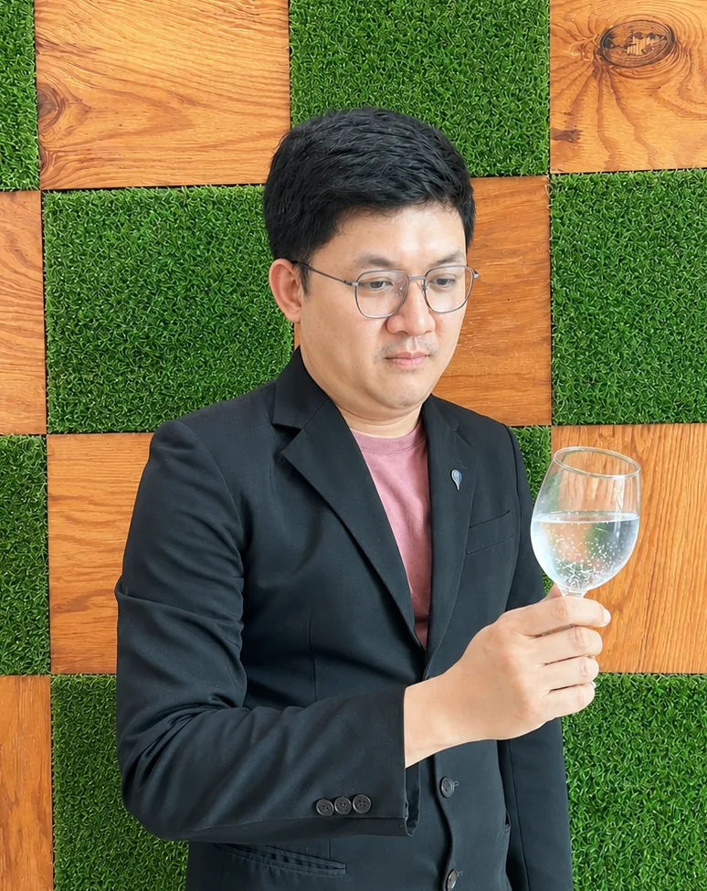 Kenneth Khoo, Certified Water Sommelier, holding a glass of fine water